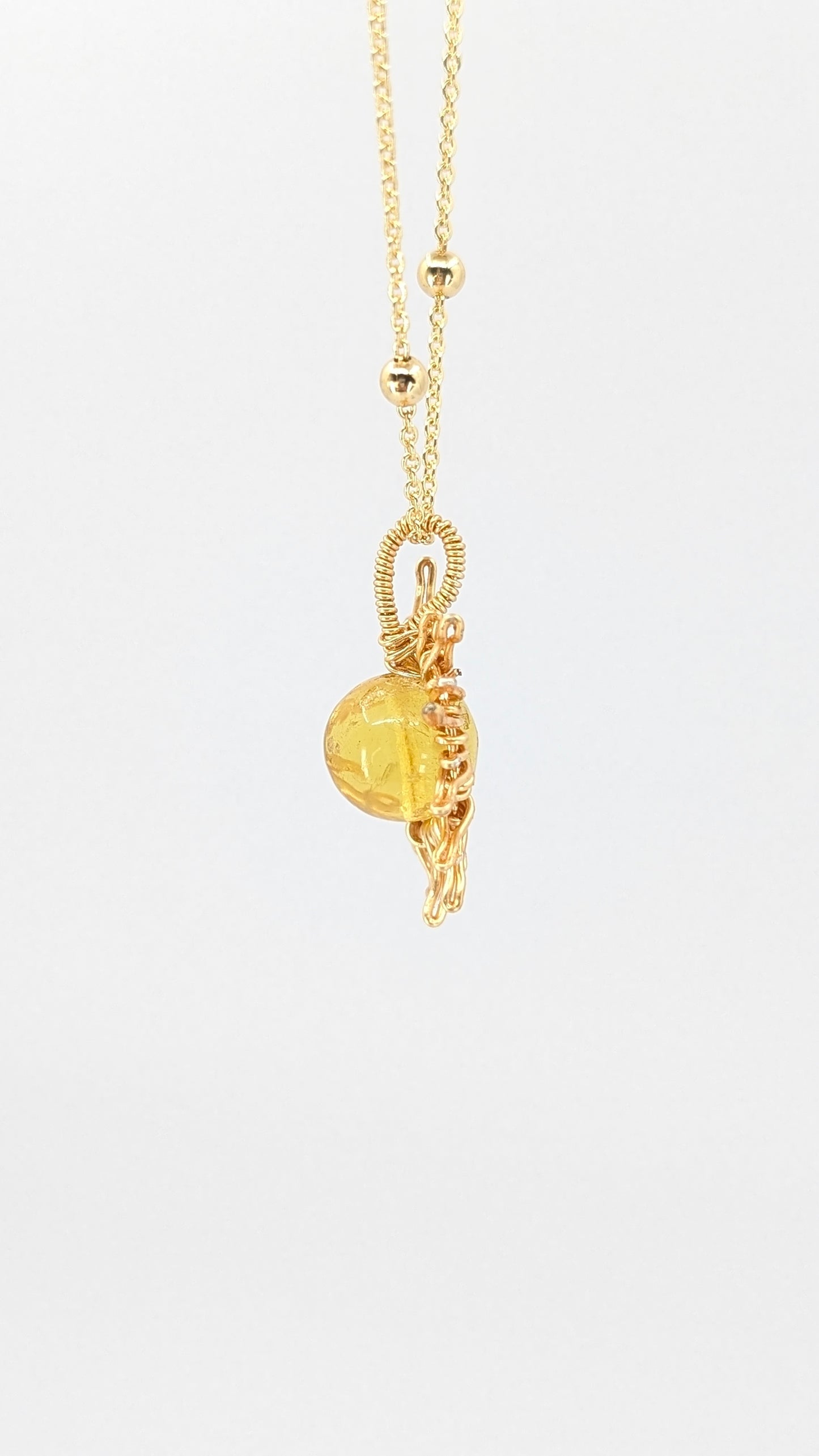 Handcrafted sun pendant necklace with light amber center stone on an adjustable gold-tone chain with bead detail