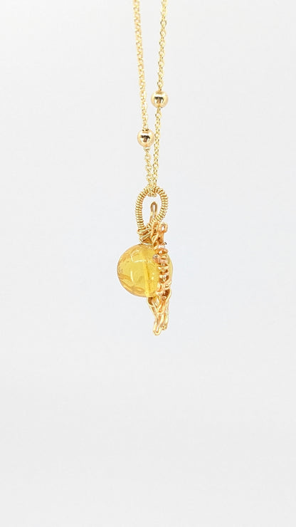 Handcrafted sun pendant necklace with light amber center stone on an adjustable gold-tone chain with bead detail