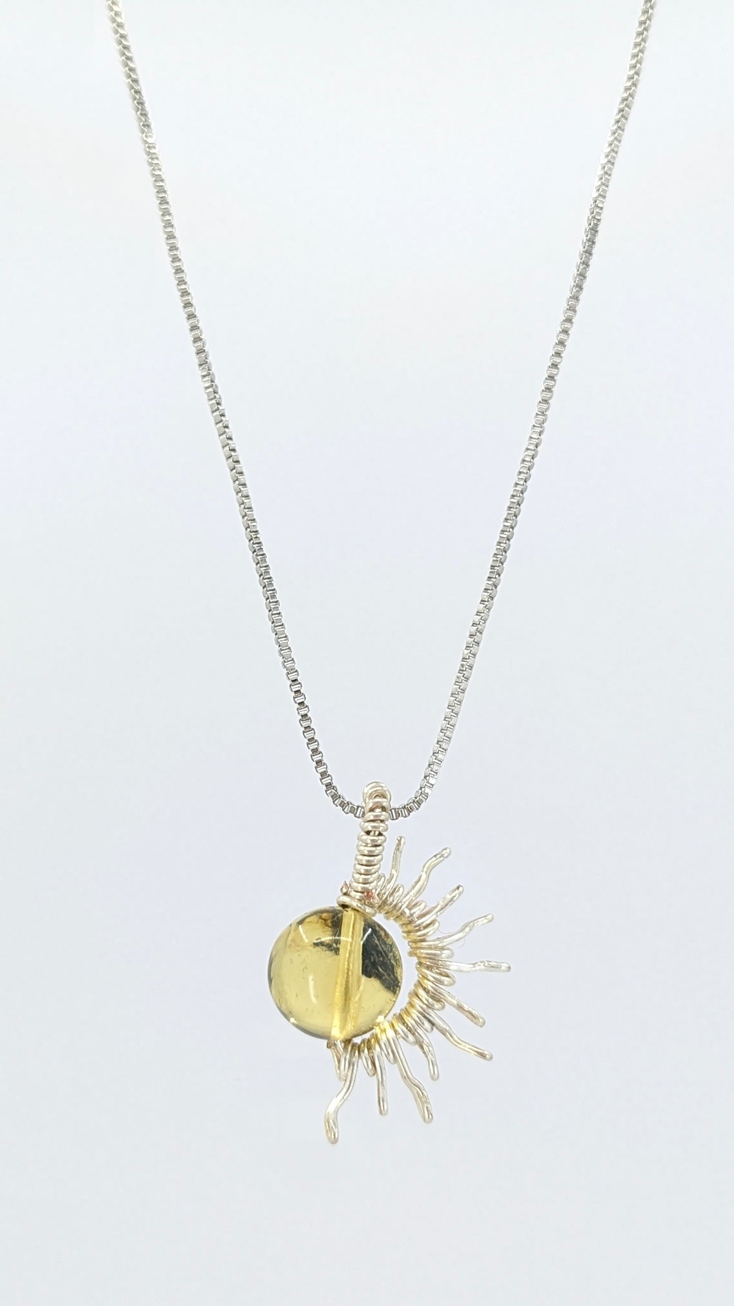 Handcrafted silver-tone half sun pendant necklace with amber center and adjustable chain