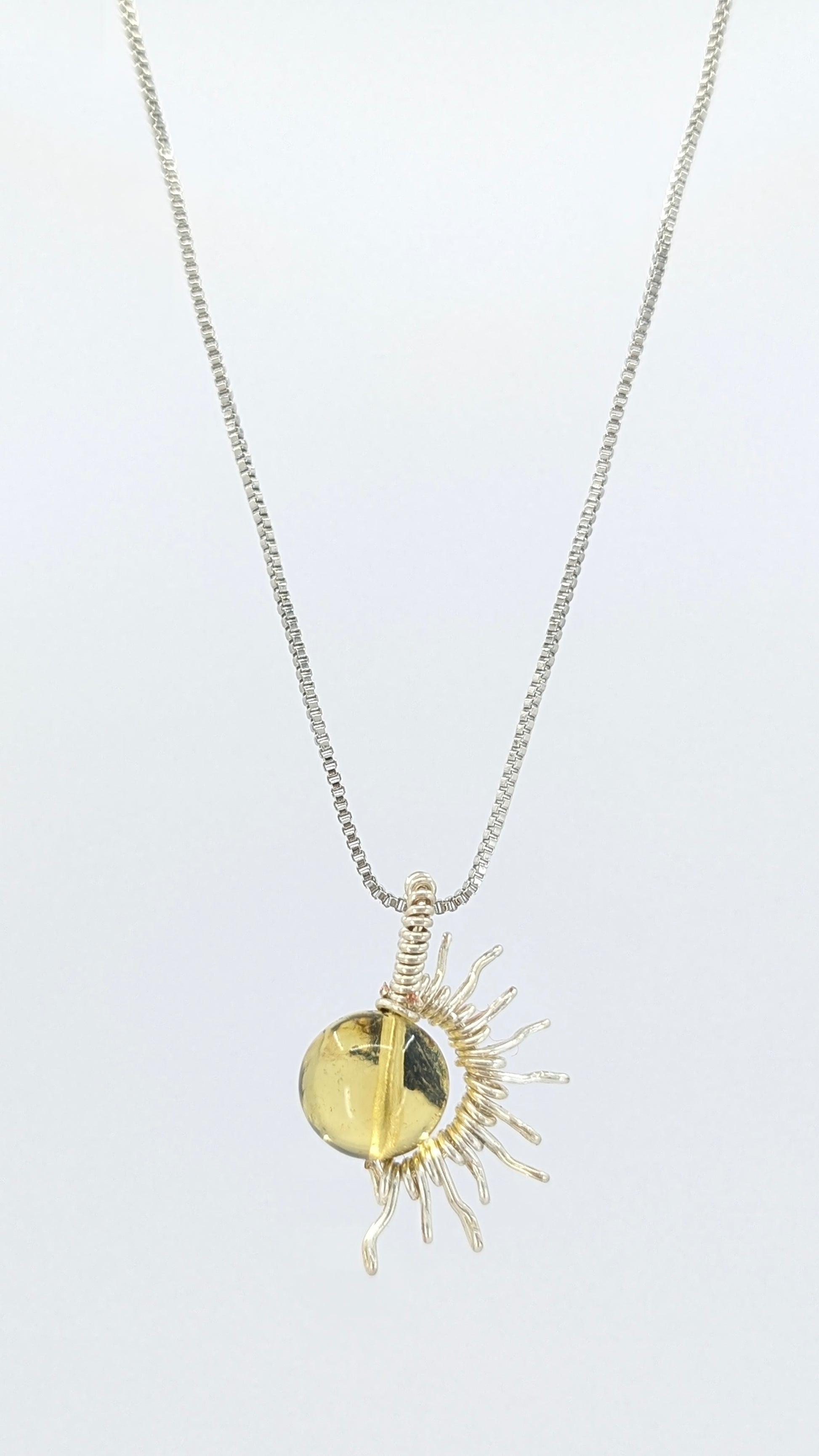 Handcrafted silver-tone half sun pendant necklace with amber center and adjustable chain