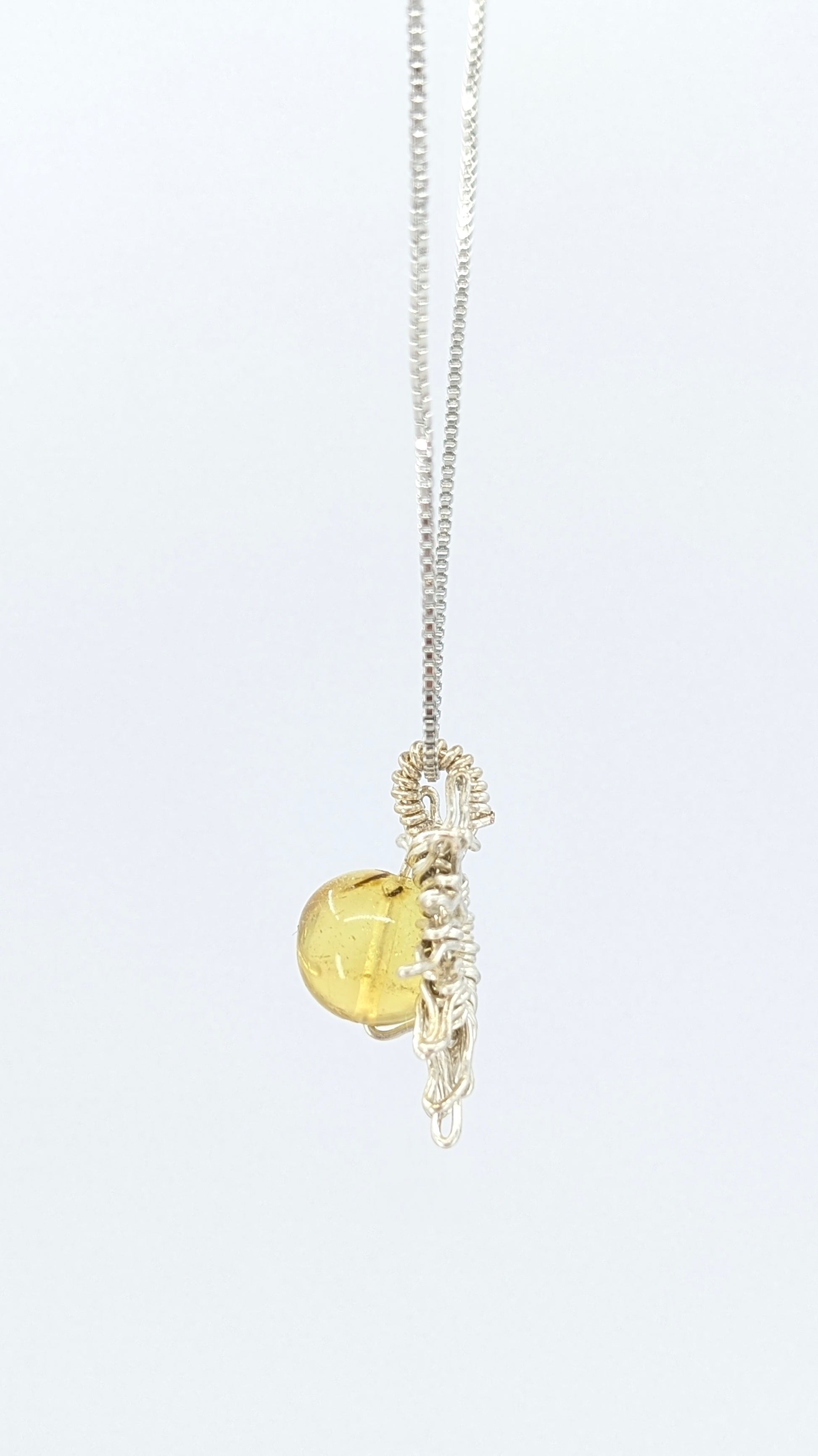 Handcrafted sun pendant necklace with rounded amber center stone on a silver-tone adjustable chain