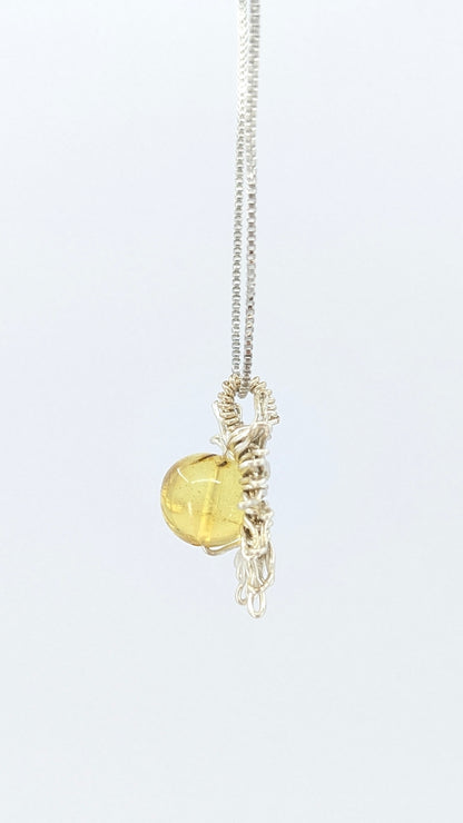 Handcrafted sun pendant necklace with rounded amber center stone on a silver-tone adjustable chain