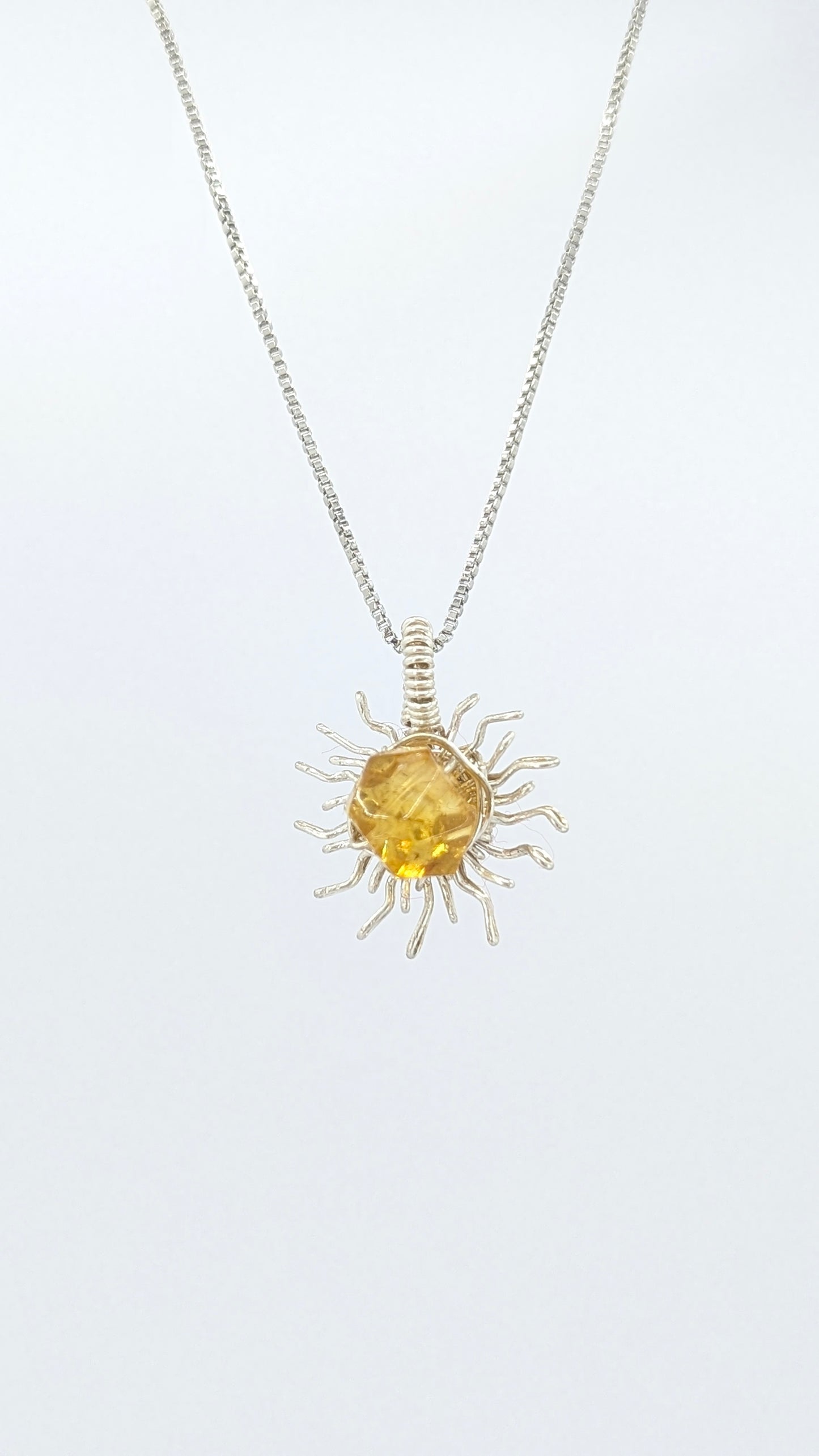 Handcrafted silver-tone sun pendant necklace with amber center stone and adjustable chain
