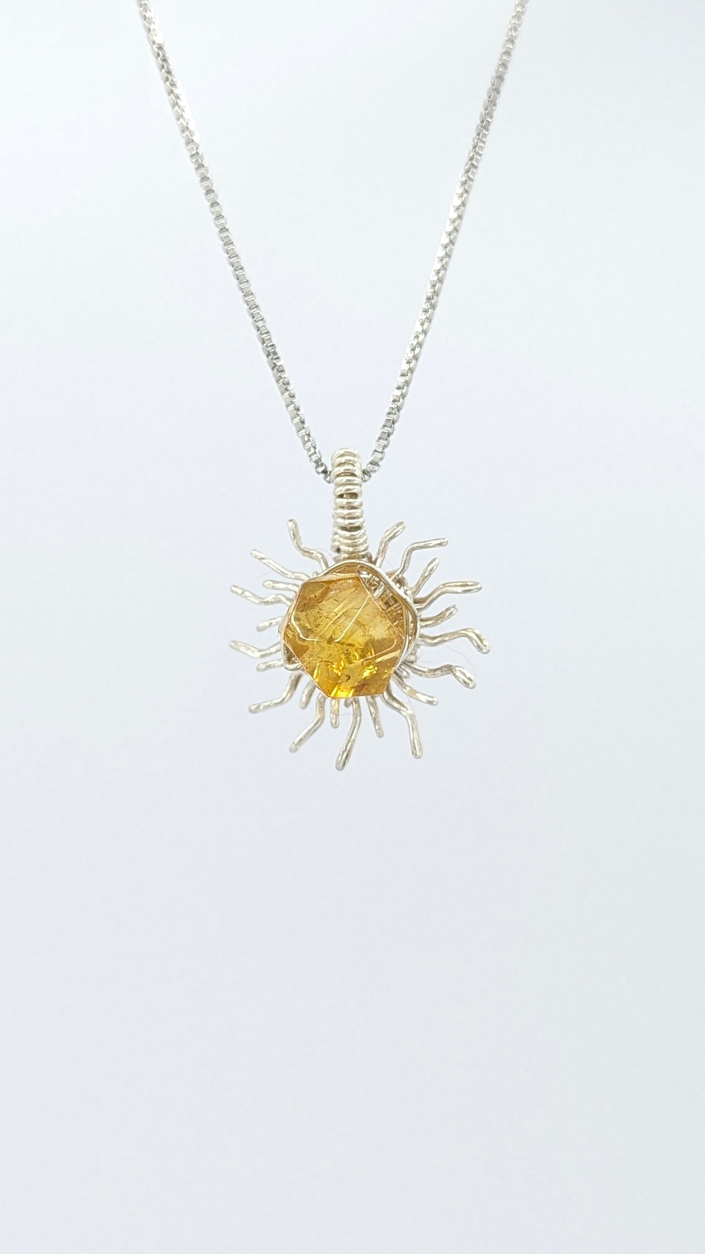 Handcrafted silver-tone sun pendant necklace with amber center stone and adjustable chain