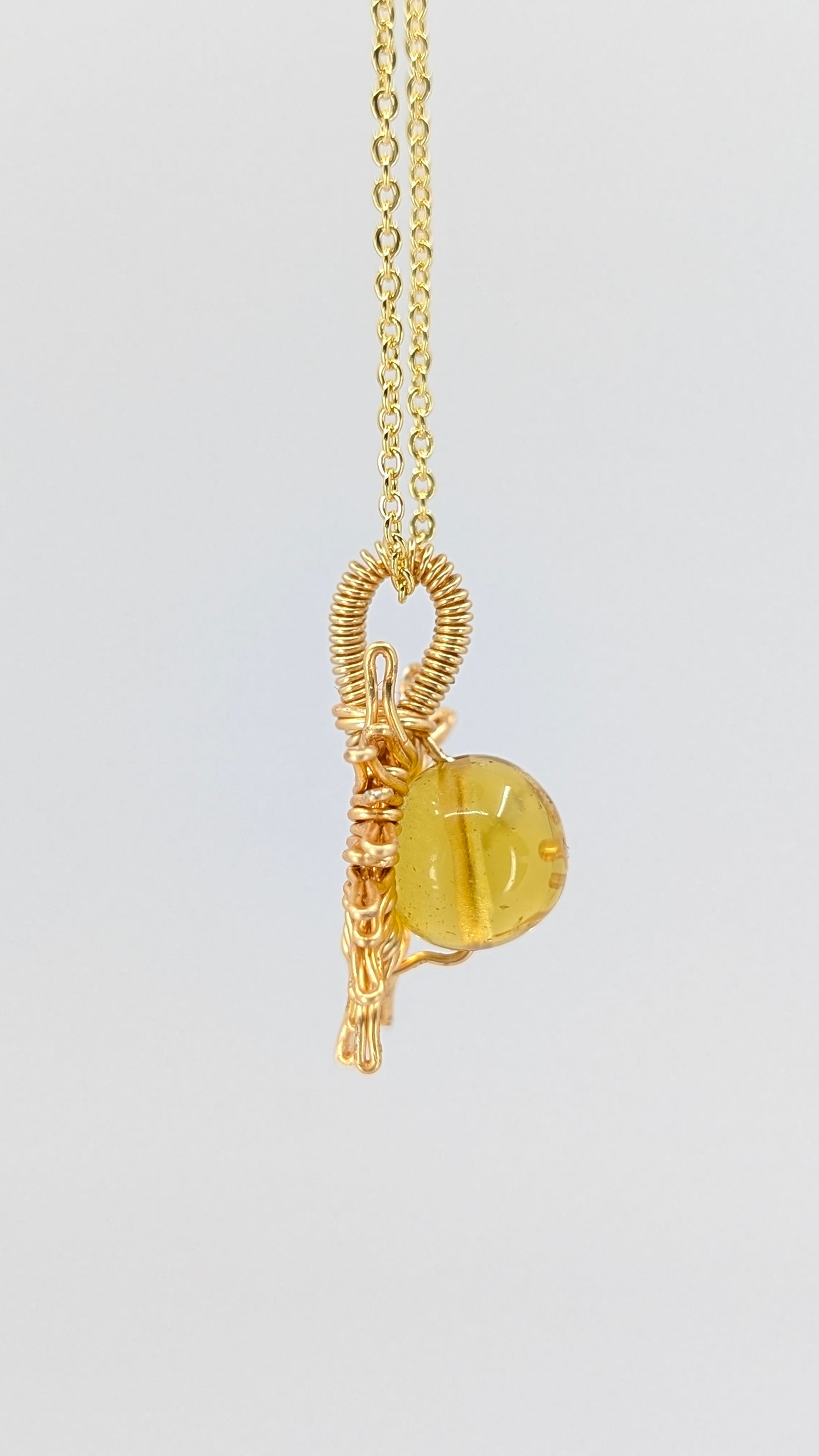 Handcrafted sun pendant necklace with very light amber rounded center stone on an adjustable gold-tone chain