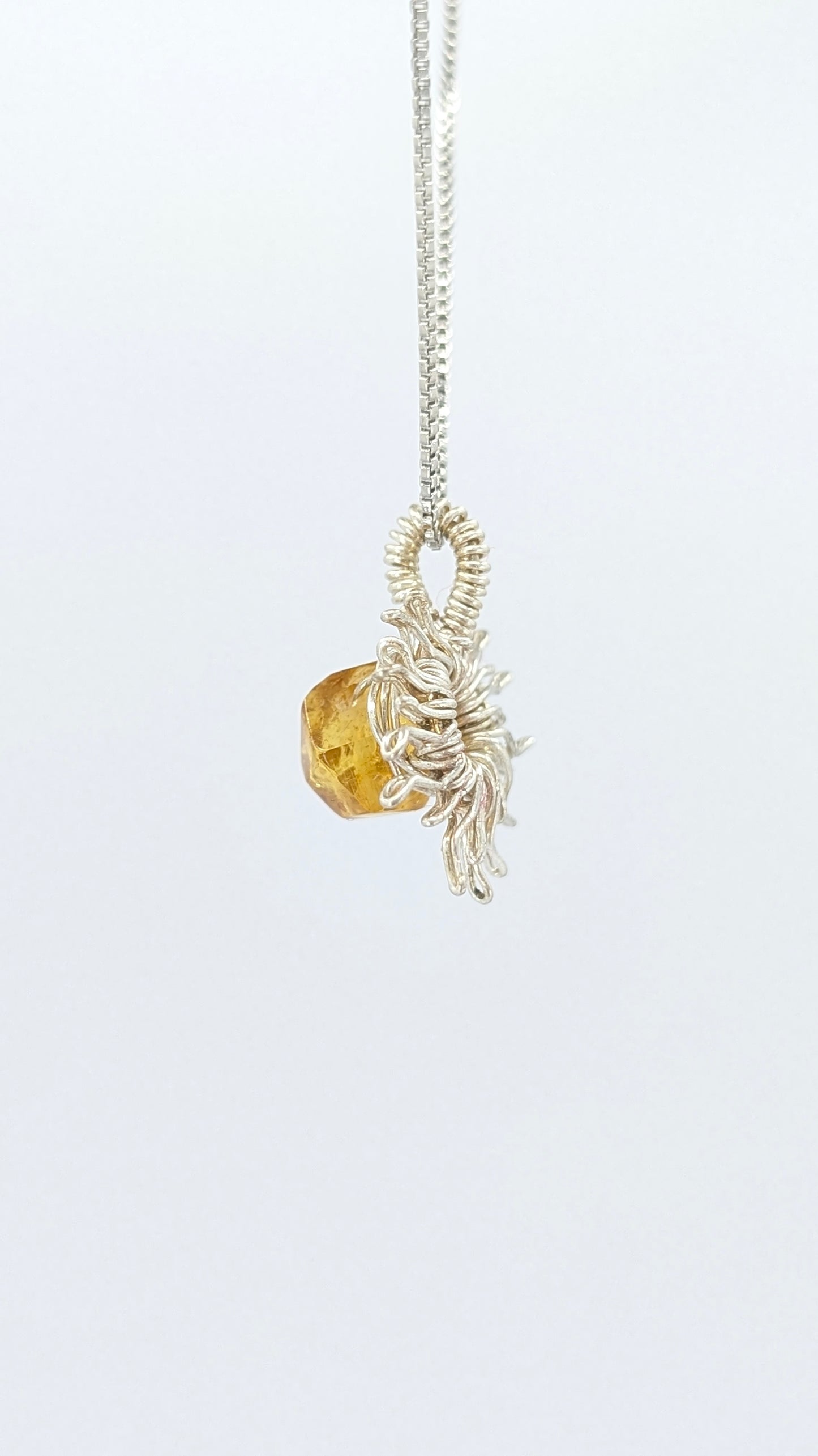 Handcrafted silver-tone sun pendant necklace with amber center stone and adjustable chain