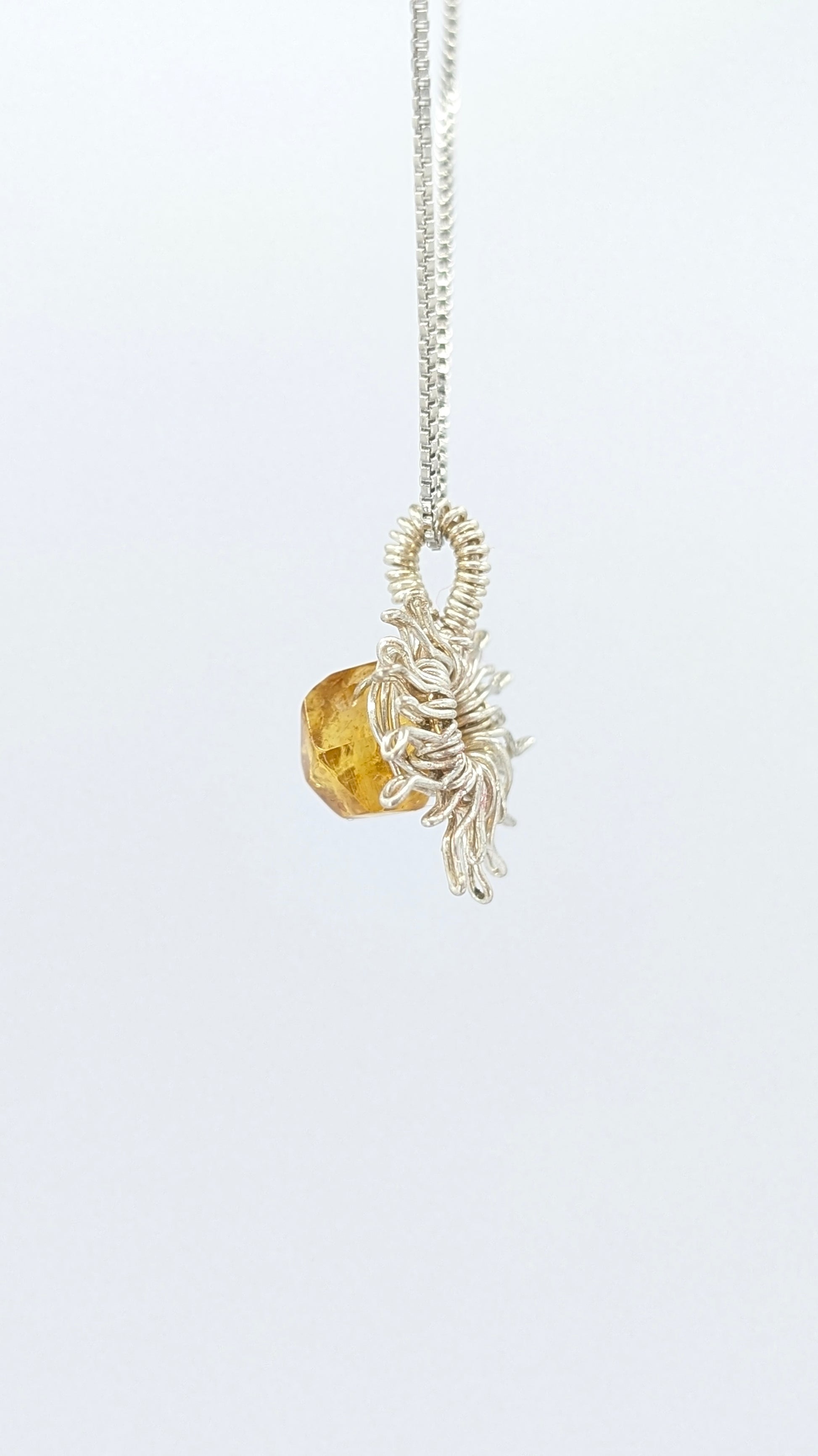 Handcrafted silver-tone sun pendant necklace with amber center stone and adjustable chain