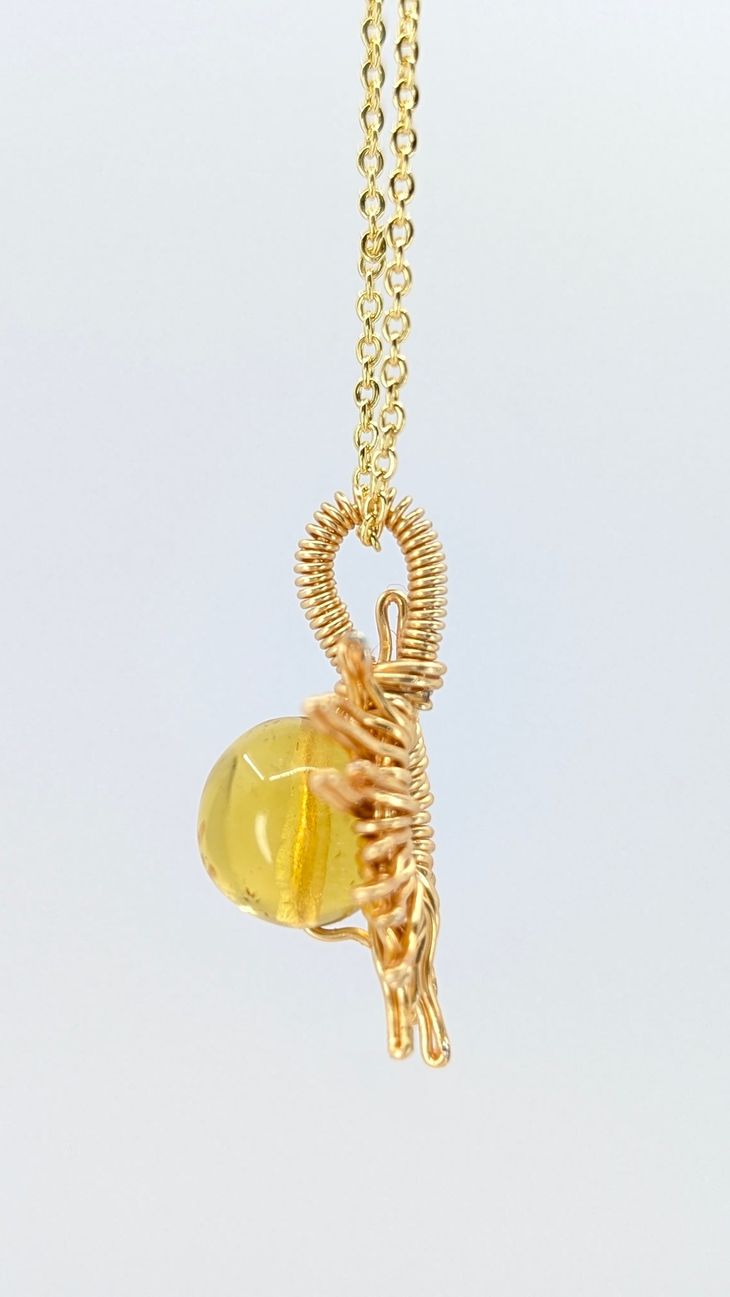 Handcrafted sun pendant necklace with very light amber rounded center stone on an adjustable gold-tone chain
