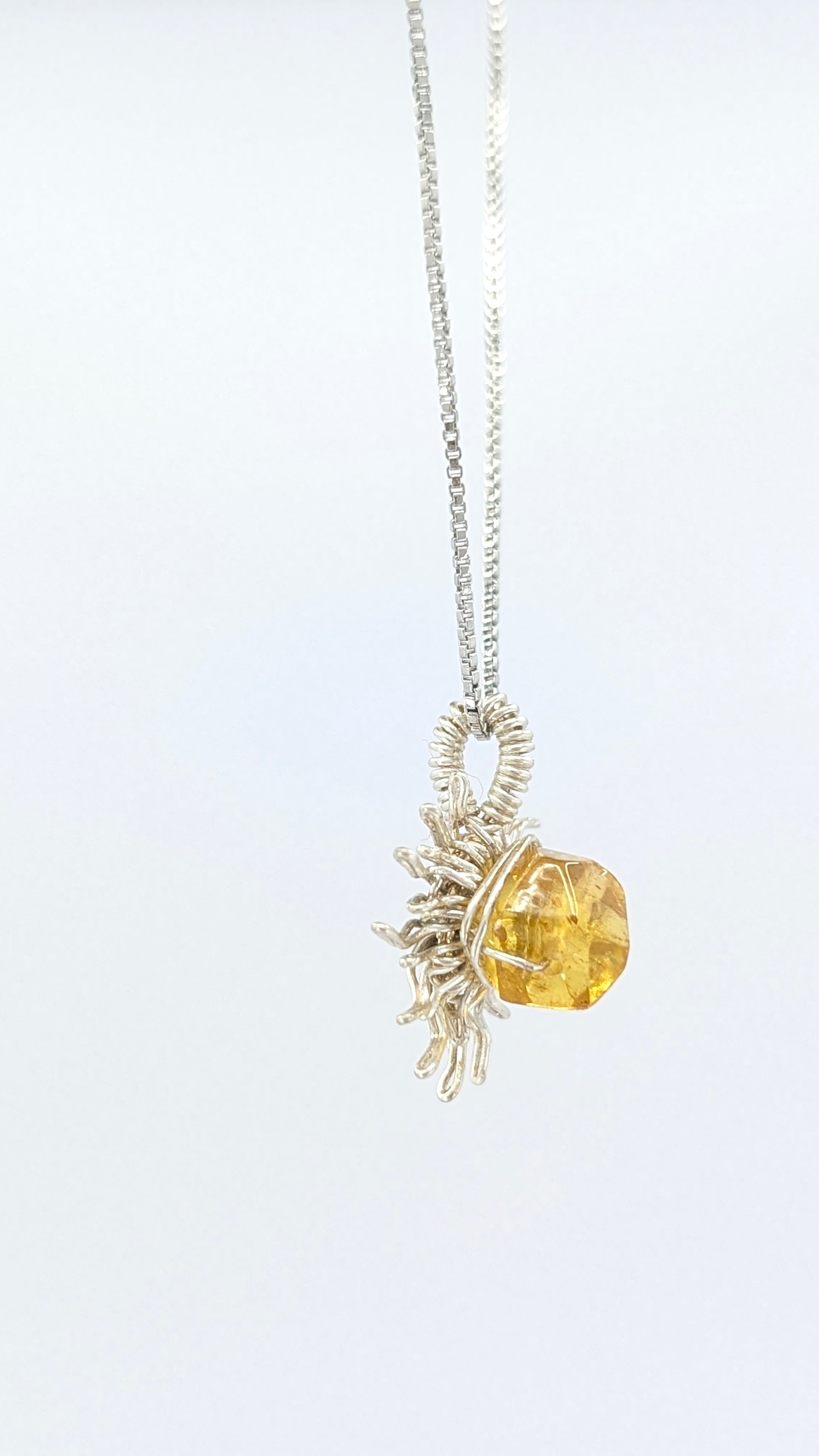 Handcrafted silver-tone sun pendant necklace with amber center stone and adjustable chain