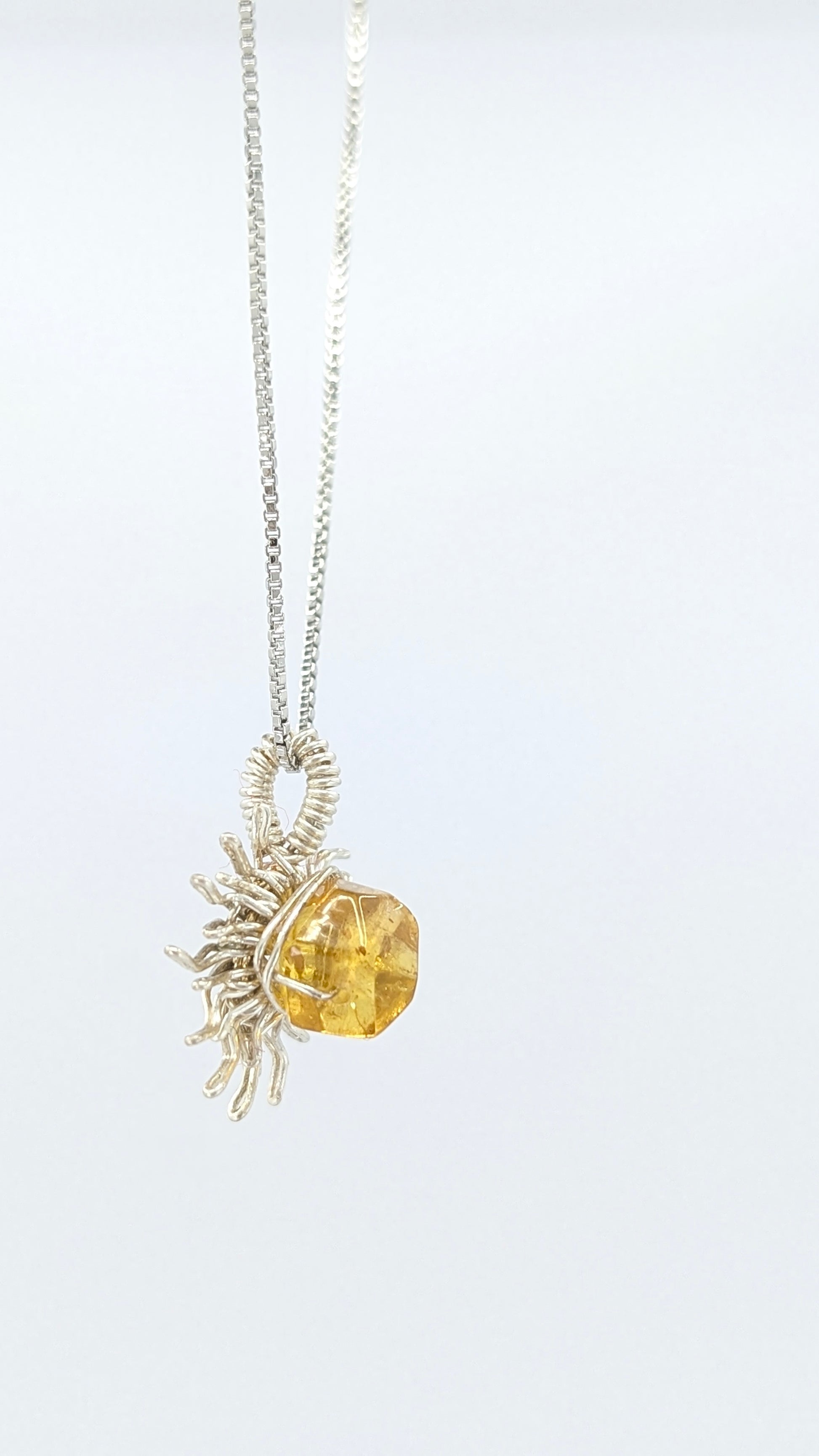 Handcrafted silver-tone sun pendant necklace with amber center stone and adjustable chain