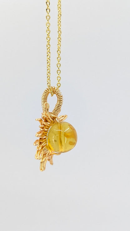 Handcrafted sun pendant necklace with very light amber rounded center stone on an adjustable gold-tone chain