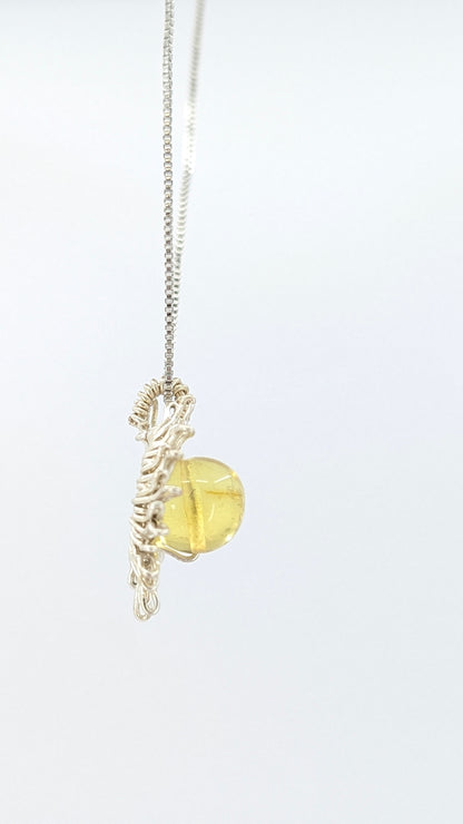 Handcrafted sun pendant necklace with rounded amber center stone on a silver-tone adjustable chain