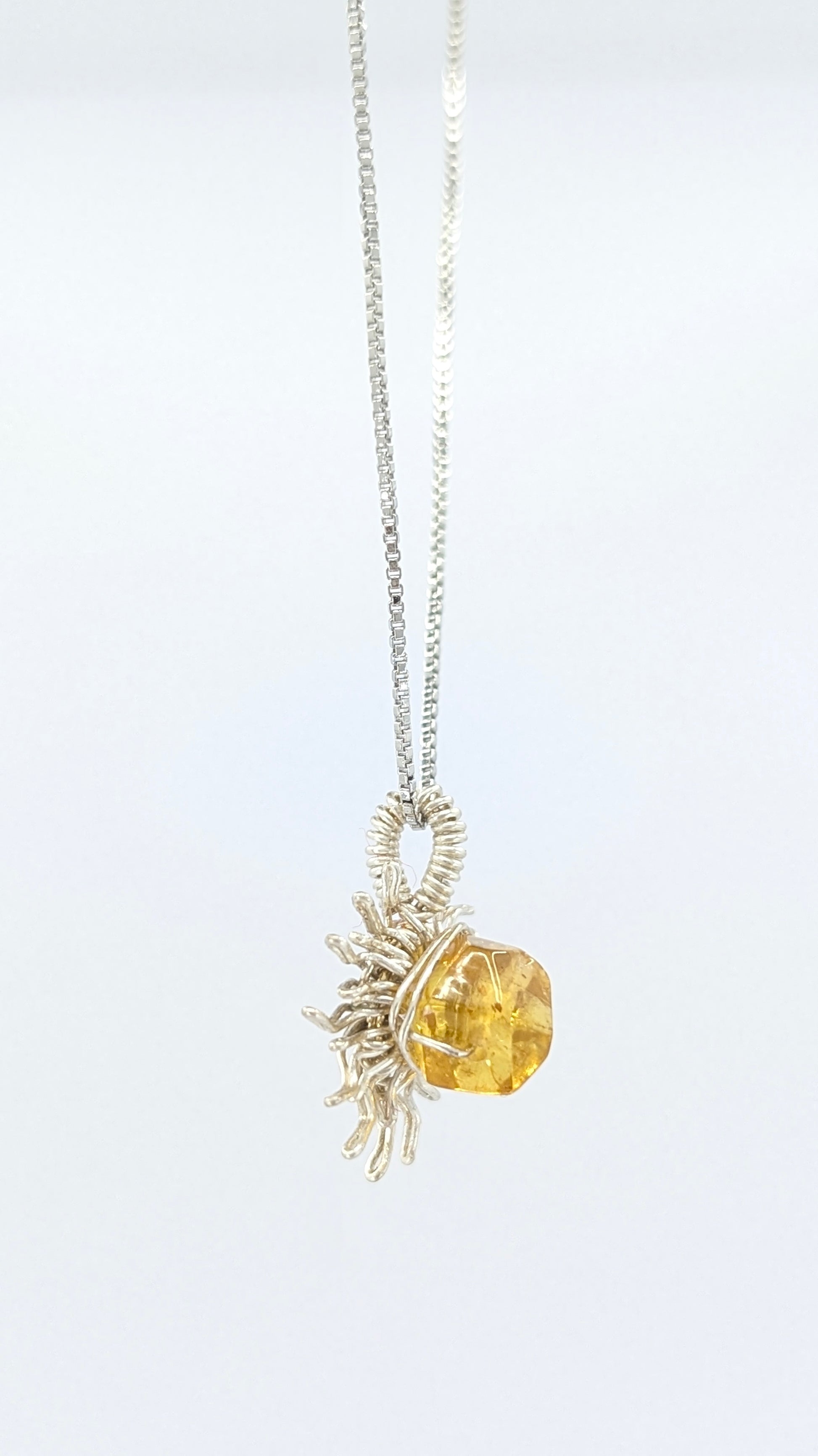 Handcrafted silver-tone sun pendant necklace with amber center stone and adjustable chain