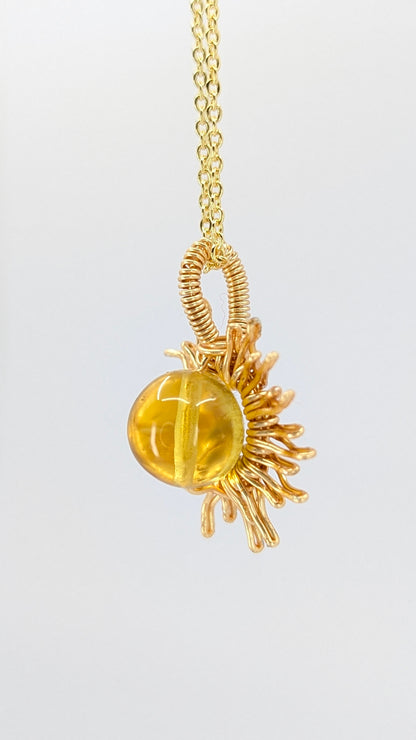Handcrafted sun pendant necklace with very light amber rounded center stone on an adjustable gold-tone chain