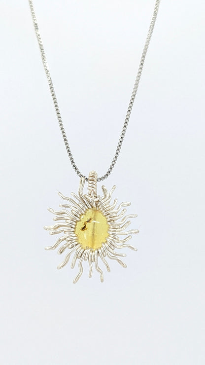 Handcrafted sun pendant necklace with rounded amber center stone on a silver-tone adjustable chain