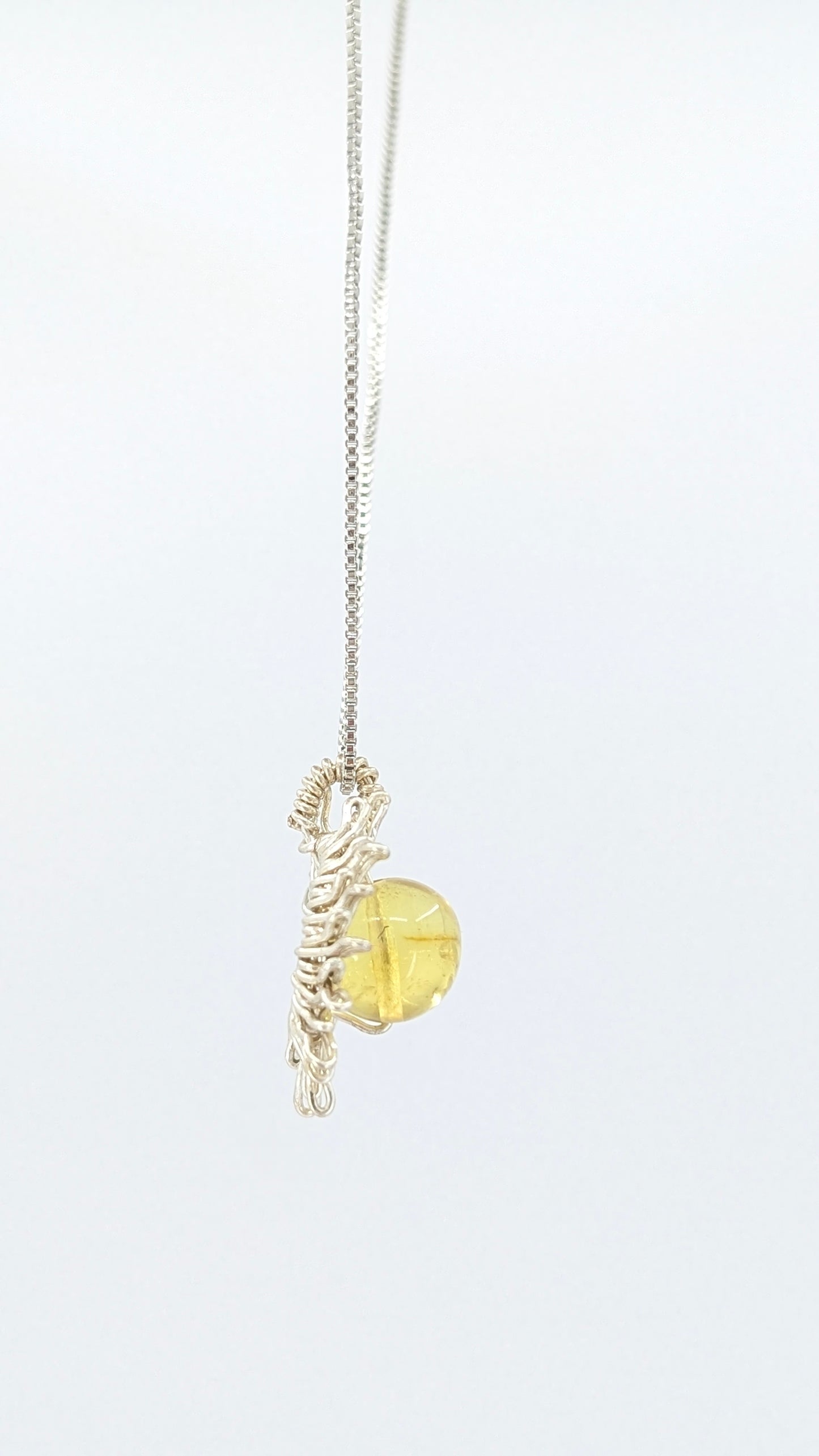 Handcrafted sun pendant necklace with rounded amber center stone on a silver-tone adjustable chain