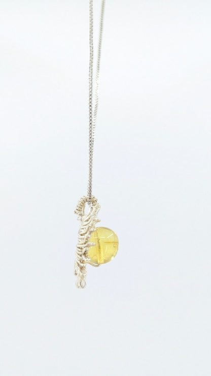 Handcrafted sun pendant necklace with rounded amber center stone on a silver-tone adjustable chain