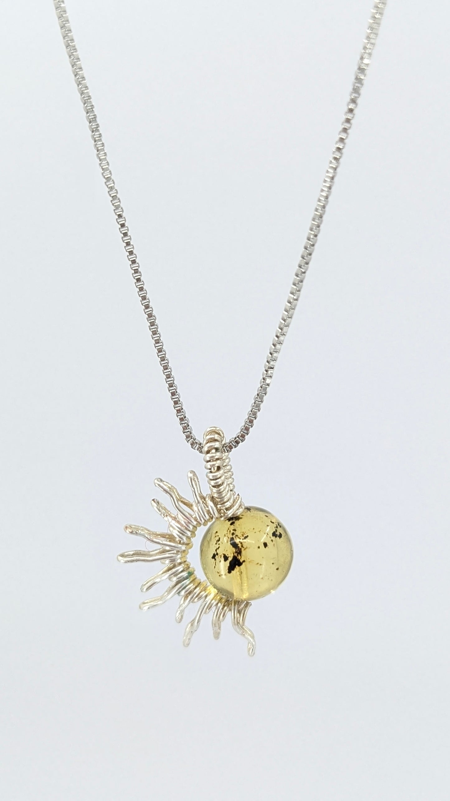 Handcrafted silver-tone half sun pendant necklace with amber center and adjustable chain