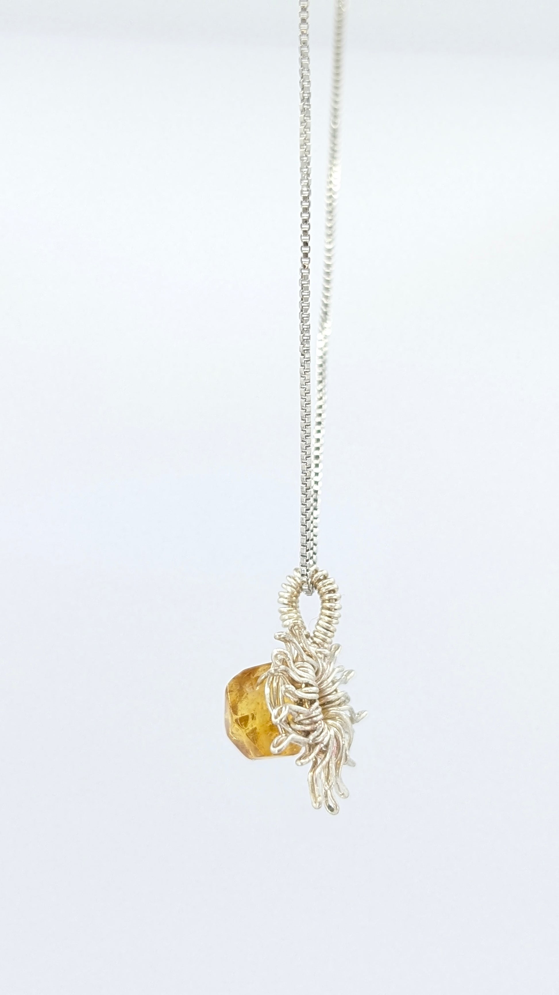 Handcrafted silver-tone sun pendant necklace with amber center stone and adjustable chain