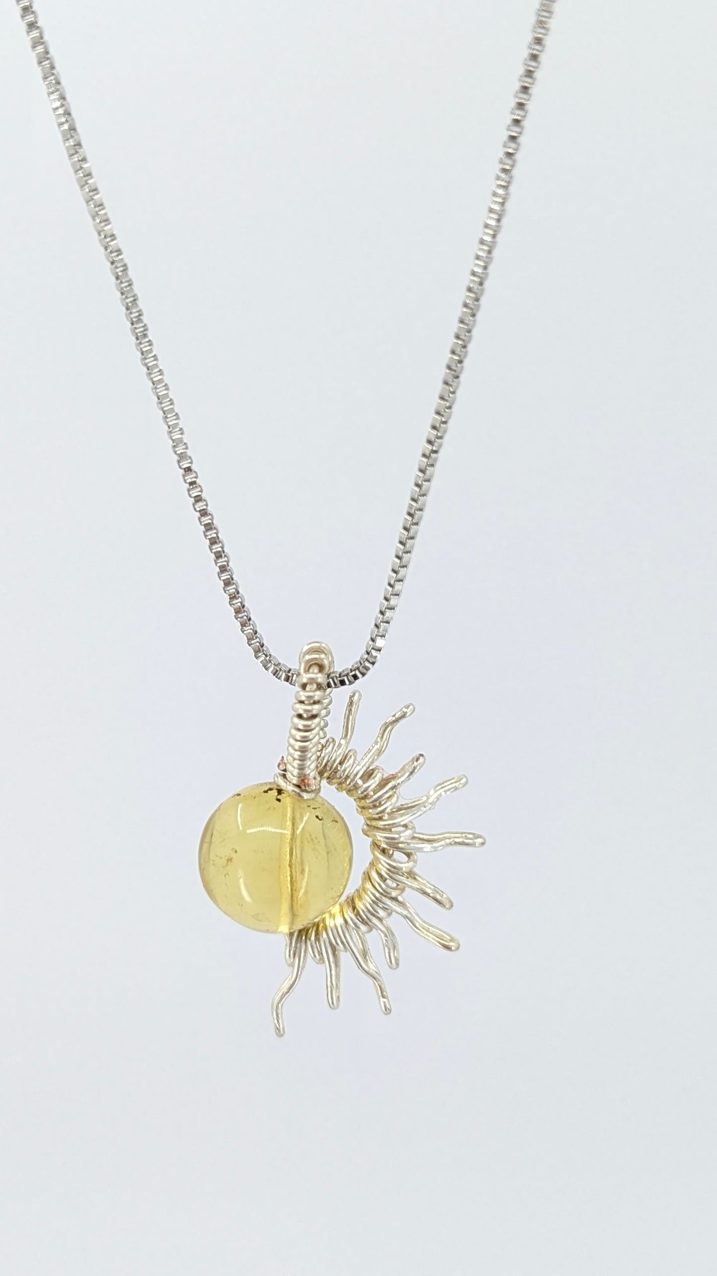 Handcrafted silver-tone half sun pendant necklace with amber center and adjustable chain