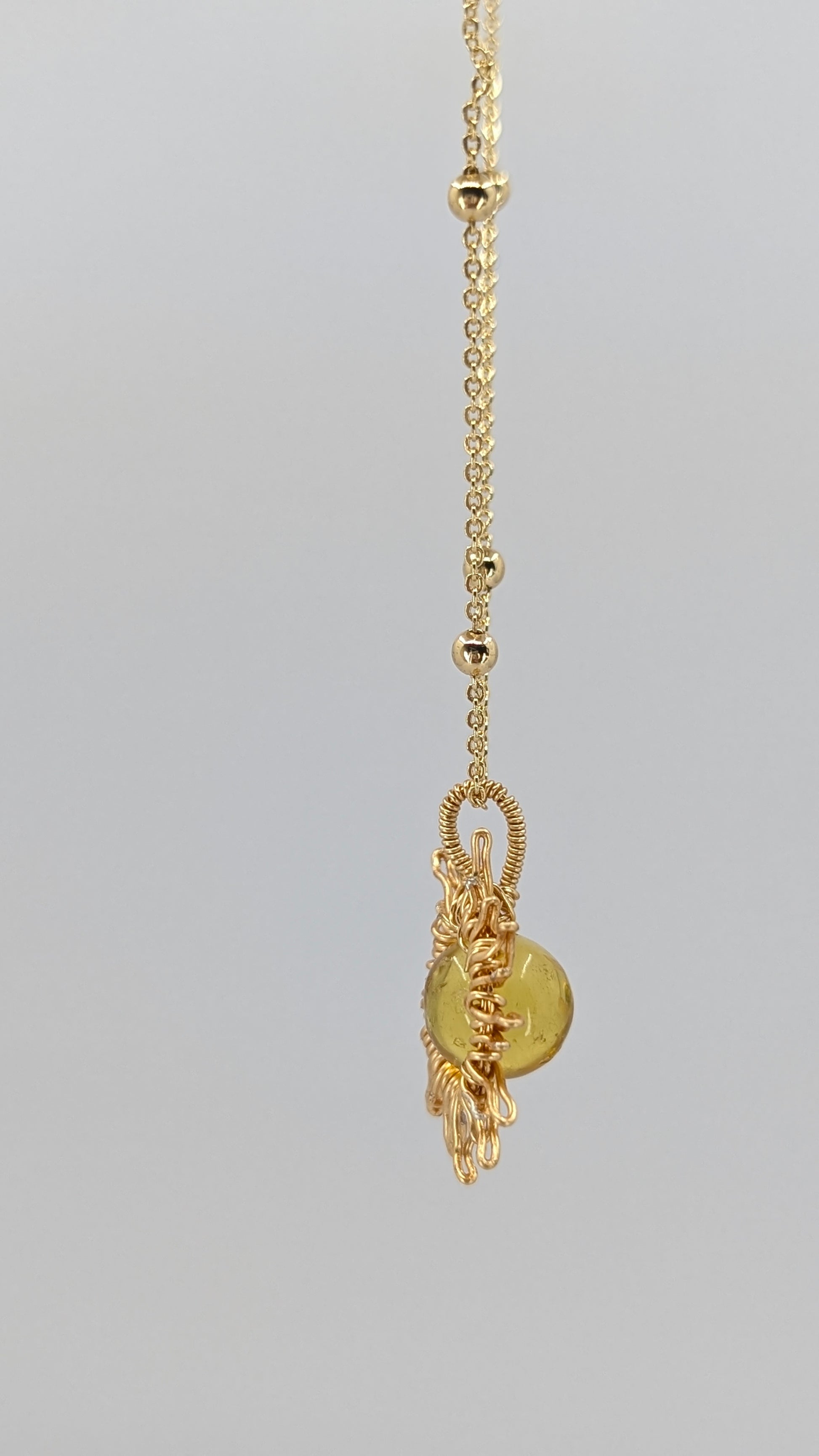 Handcrafted sun pendant necklace with light amber center stone on an adjustable gold-tone chain with bead detail